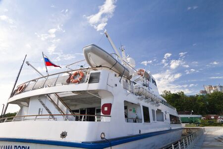 The boat at the mooring costs waiting for passengers in the light of a bright sunのeditorial素材