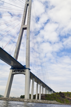 Huge suspension bridge on the island in bright beams of the sunの写真素材