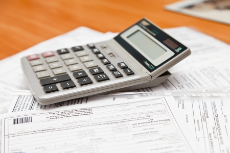 The calculator lies on accounting documents on a tableの写真素材