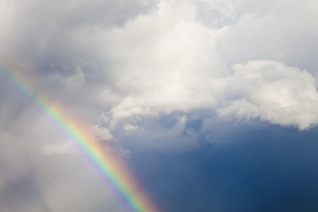 Rainbow in the sky against dark clouds and a rainの写真素材