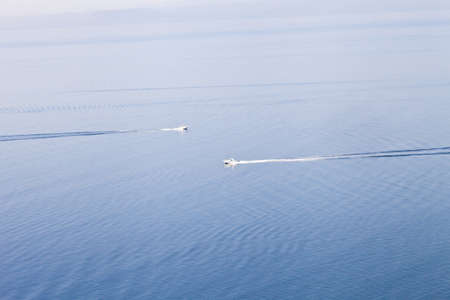 The boat goes to the sea in a clear weather during a full calmの写真素材