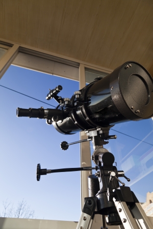 The telescope looks out of the window waiting for stars