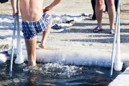 Bathing in an ice ice-hole in the bright frosty afternoonの写真素材