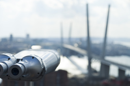 The tourist telescope looks at the sea and a big suspension bridgeの写真素材