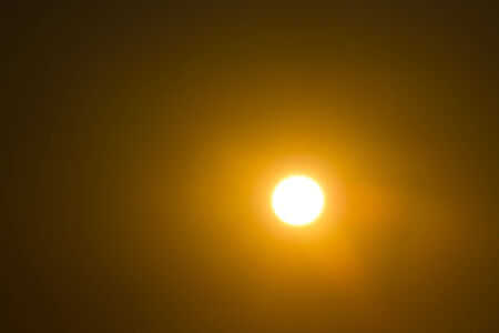 The sun at sunset over the heavy evening sea