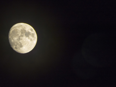 The moon in the night sky shines very brightlyの写真素材
