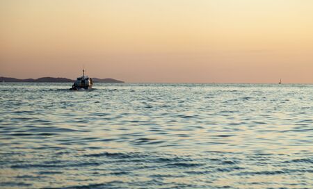 The sea at sunset in beams of the red setting sunの写真素材