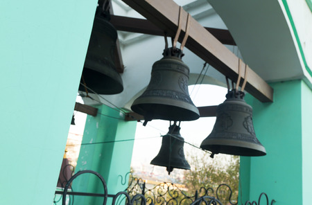 Bells on a belfry waiting for evening service and the bell ringerの写真素材
