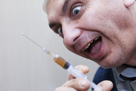 The syringe in a hand is filled narkotiyey for reception of a doseの写真素材
