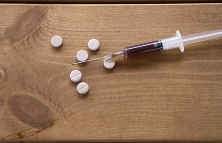 The syringe on a table is filled with drug for a prick
