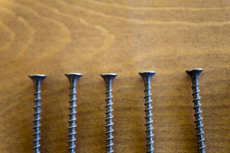 Screws on a table lie waiting for applicationの写真素材