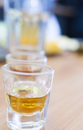 The alcohol shot glass on a table waits when it is drunkの写真素材