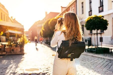 Young blonde tourist is exploring beautiful european city streets