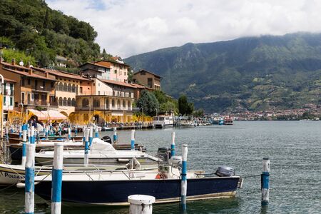 Monte Isola, Italy - June 29, 2017: Boats in the harbor of the island of Monte Isola on Lake Iseo with a view of the mountains - travel and natural background.のeditorial素材