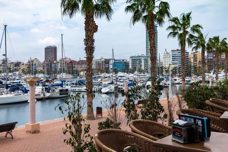 ALICANTE, SPAIN - April 26, 2018: view from a cafe with rattan furniture on a port with yachts and a waterfrontのeditorial素材