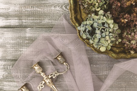 Vintage tray with dried blue hydrangea flowers and a silver candlestick on a gray table. Flat style....
