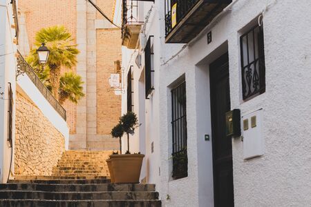 Altea, Spain - 19 February 2019: Beautiful narrow street in the old town with white houses and a cobblestone roadのeditorial素材