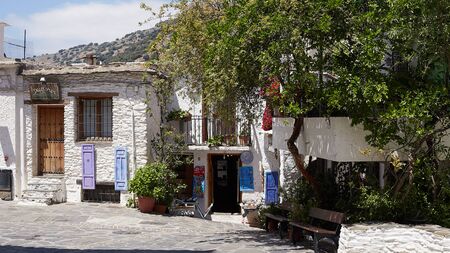 Capileira, Andalusia, Spain - May 29, 2019: narrow paved street with a depression for a mountain stream, white houses decorated with lanterns, Capileira Spainのeditorial素材