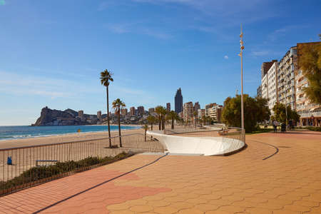 Benidorm, Alicante, Spain - November 27, 2019: people walk along the fantastic modern promenade of Poniente with views of skyscrapers, palm trees, rocks.のeditorial素材