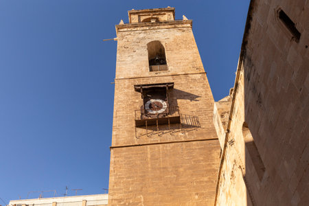 Bell tower with an old clock in the city of Orihuela, province of Alicante, Spain.