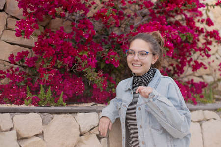 Close-up portrait of a beautiful, young Caucasian sixteen year old laughing girl in a denim jacket...