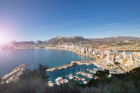 Coastline of the Mediterranean resort of Calpe, Spain with sea and yachts, lake, skyscrapers and mountain rangeの写真素材