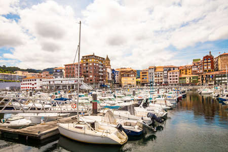 Bermeo, Basque Country, Spain - July 16, 2020: fishing port with colorful facades of houses and fishing boats against the backdrop of a beautiful cloudy skyのeditorial素材