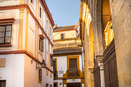 Cordoba, Andalusia, Spain - November 5, 2021: Facades of houses with tiled roofs and an ancient building with arches in the Old Townのeditorial素材