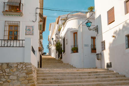 Beautiful narrow street with cobblestone stairs in an old town with white houses and tiled roofs. Altea, Spainのeditorial素材