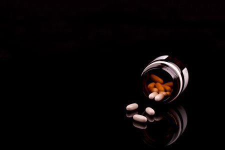 Medical concept of prescription pills and bottle on black background, with reflection, copy spaceの写真素材
