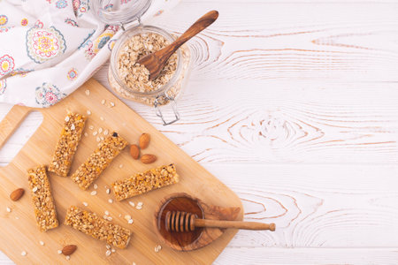 Top view of cereal muesli bar with nuts and honey on a white wooden table. Healthy sweet dessert snack.の写真素材