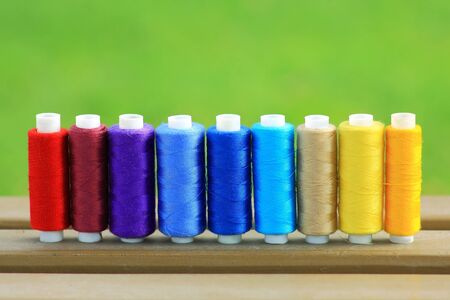  olorful spools of thread in a row