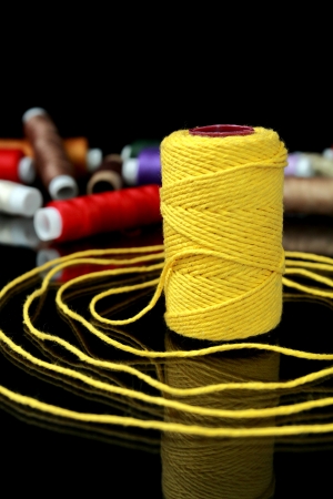Focus on one reel of thread on a black backgroundの写真素材