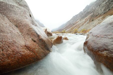 A waterfall with a mountain in the backgroundの写真素材