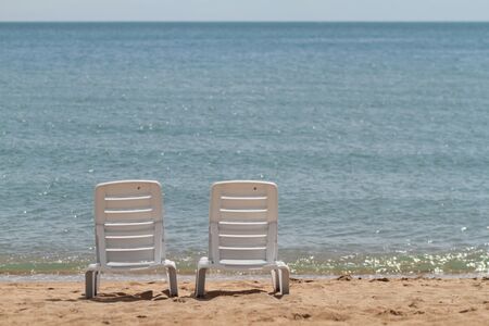 Deck chair in the sand on the shore. Relax, relaxation on the beach. Blue water in the ocean sea. Travel to the sea of the island. Holidays at sea. Air tourism. High quality photoの写真素材