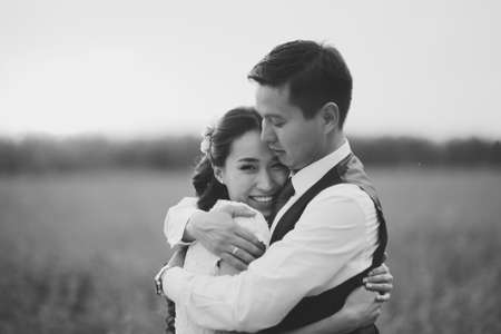 The bride and groom hold hands, hug each other and walk in the park. wedding. High quality photoの写真素材