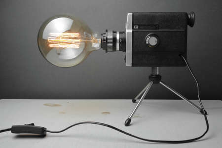 Retro lamp from an old camera with an Edison lamp on a gray background. Concept is a good idea. High quality photoの写真素材
