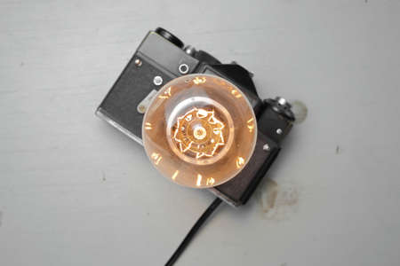 Retro lamp from an old camera with an Edison lamp on a gray background. Concept is a good idea. High quality photoの写真素材