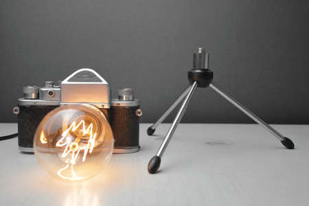Retro lamp from an old camera with an Edison lamp on a gray background. Concept is a good idea. High quality photoの写真素材