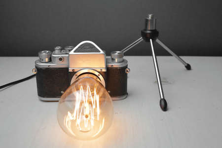 Retro lamp from an old camera with an Edison lamp on a gray background. Concept is a good idea. High quality photoの写真素材