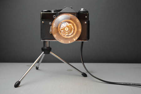 Retro lamp from an old camera with an Edison lamp on a gray background. Concept is a good idea. High quality photoの写真素材