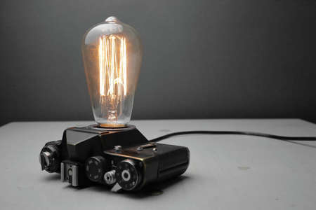 Retro lamp from an old camera with an Edison lamp on a gray background. Concept is a good idea. High quality photoの写真素材