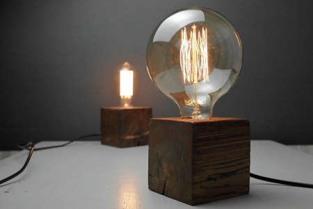 Retro wood lamp with Edison lamp on a gray background. The concept is a good idea. High quality photoの写真素材