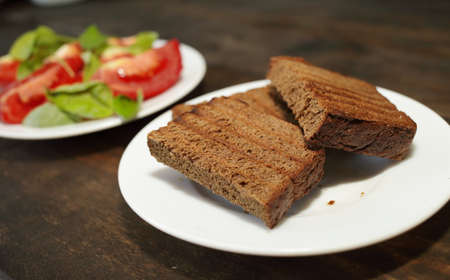 Fresh bread toast. Sliced tomatoes with lettuce on a white plate. Healthy eating conceptの写真素材
