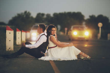 Happy bride and groom in the light of car headlights Wedding. Happy love conceptの写真素材