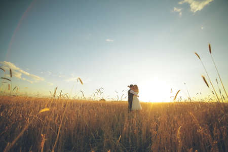 The bride and groom hug each other in the park at sunset Wedding. Happy concept.の写真素材