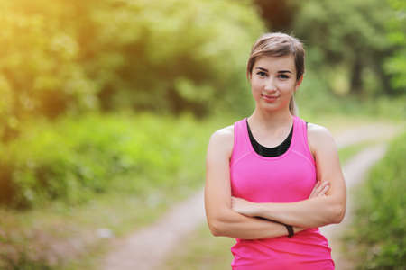 Young fitness woman running in the morning forest trail. Motivation healthy fit living. Running shoe of the person running in nature with beautiful sunlight. Woman warming up before runningの写真素材