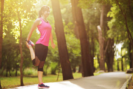 The young woman is engaged in sports fitness in nature forest Healthy fit livingの写真素材