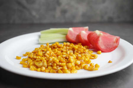 Diet. Organic Grilled Corn, tomato, cucumber on a white plate. Organic farm vegetables. Environmentally friendly productsの写真素材