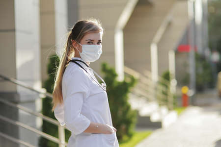 Confident female doctor or nurse wearing a face protective mask. Safety measures against the coronavirus. Prevention Covid-19 healthcare concept. Stethoscope over the neck. Woman, girl.の写真素材